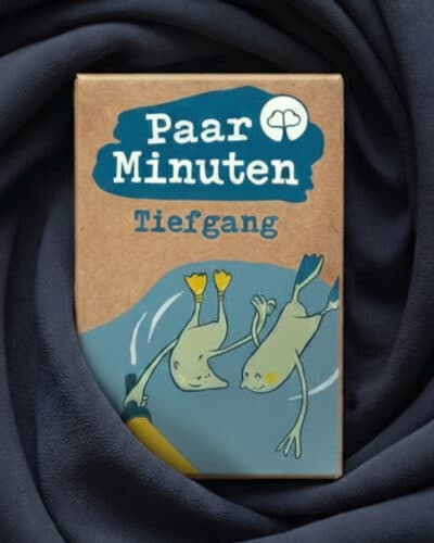 Schachtel PaarMinuten Tiefgang auf dunkelblau drapiertem Stoff, die Illustration zeigt zwei tauchende Robben